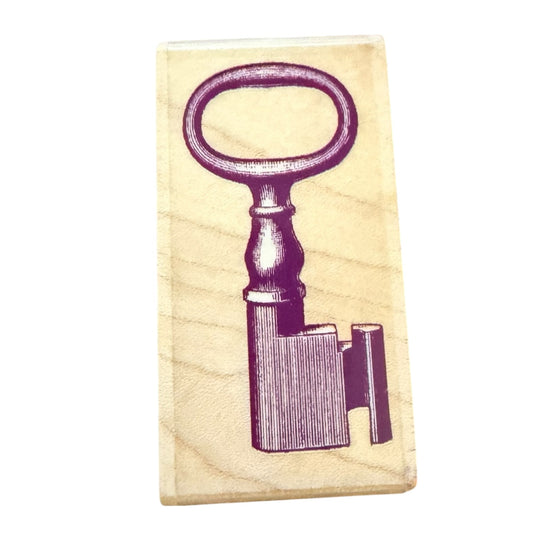 Wood stamp with a purple key design on a white background