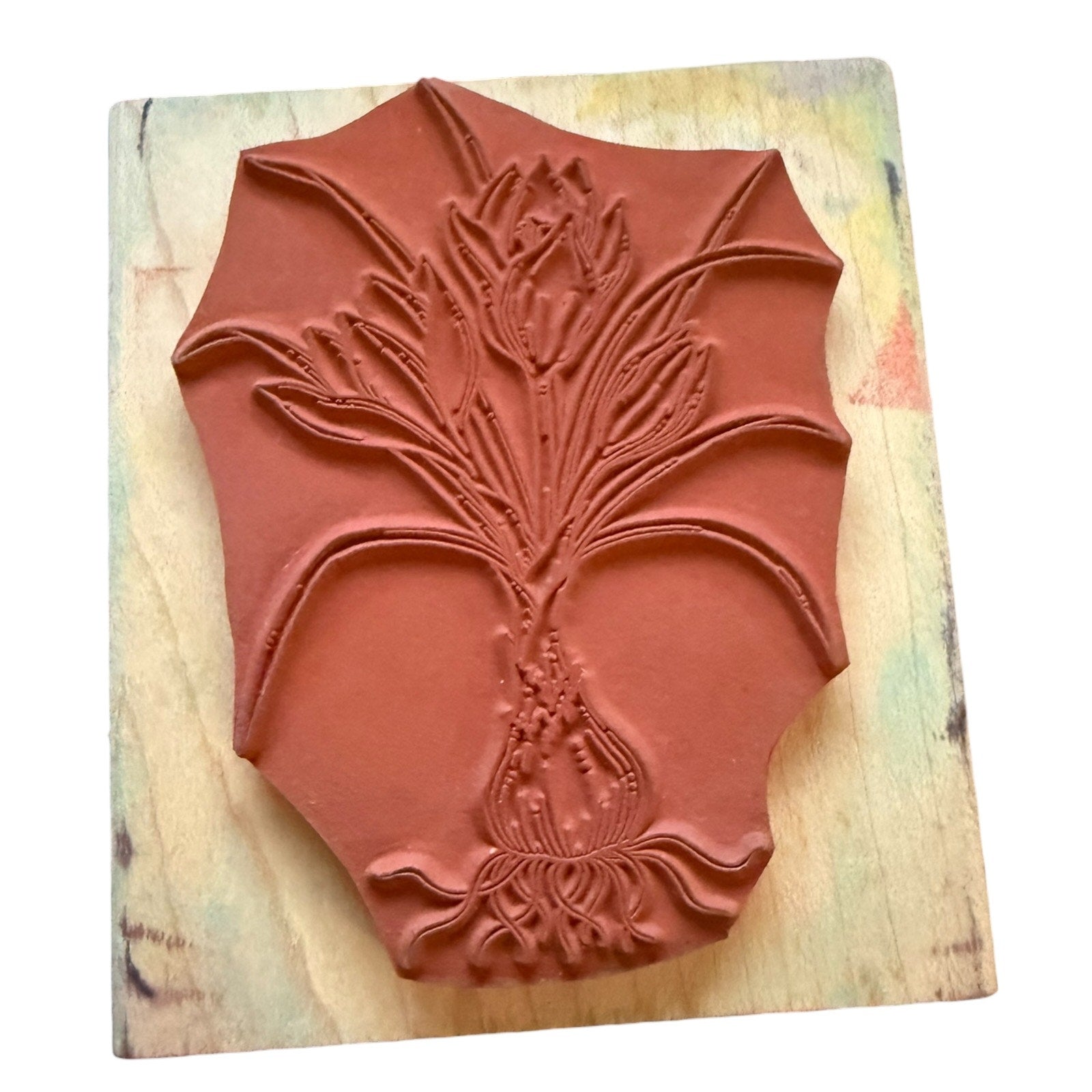 Decorative rubber stamp with floral design on a wooden surface