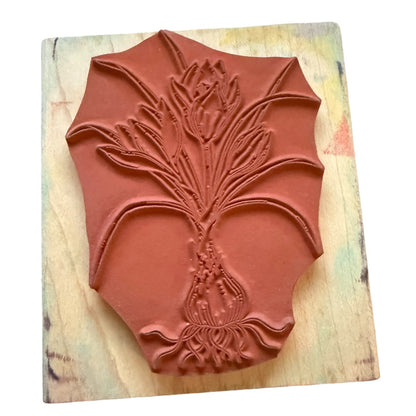 Decorative rubber stamp with floral design on a wooden surface