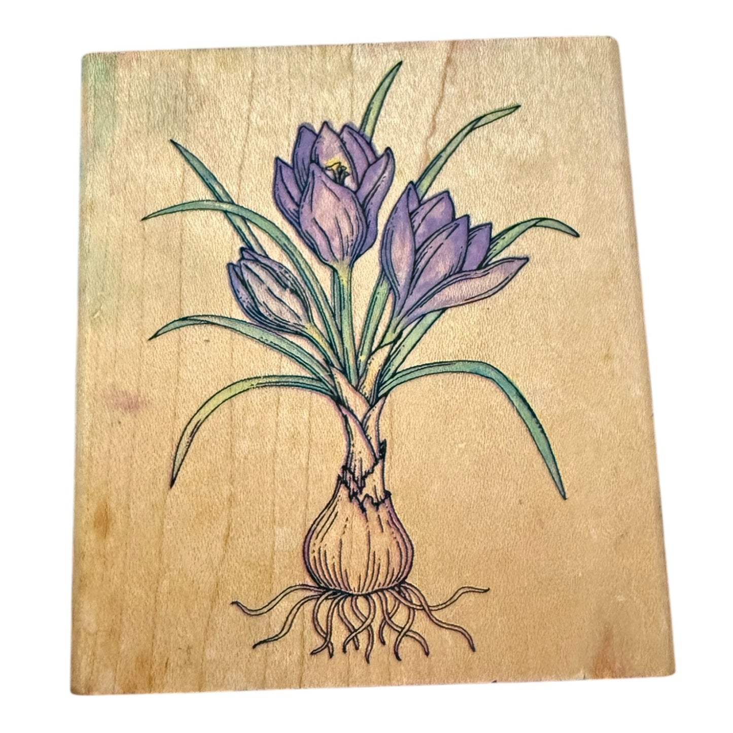 Wooden stamp block with a purple flower illustration on a white background