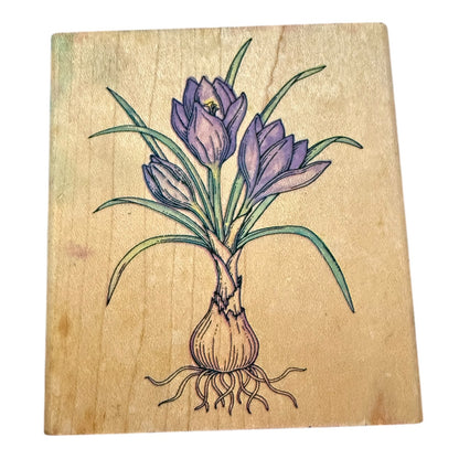 Wooden stamp block with a purple flower illustration on a white background