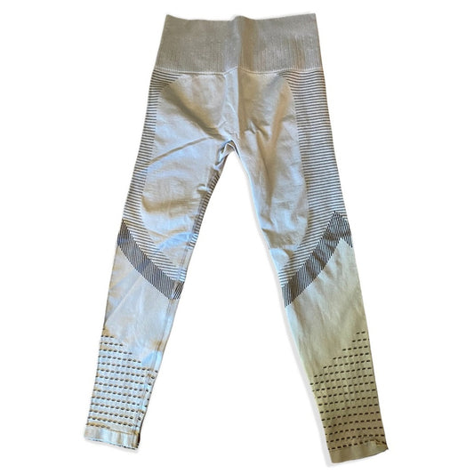 A pair of high-waisted athletic leggings in a gray, featuring textured knit panels, horizontal stripe patterns, and perforated details near the ankles.