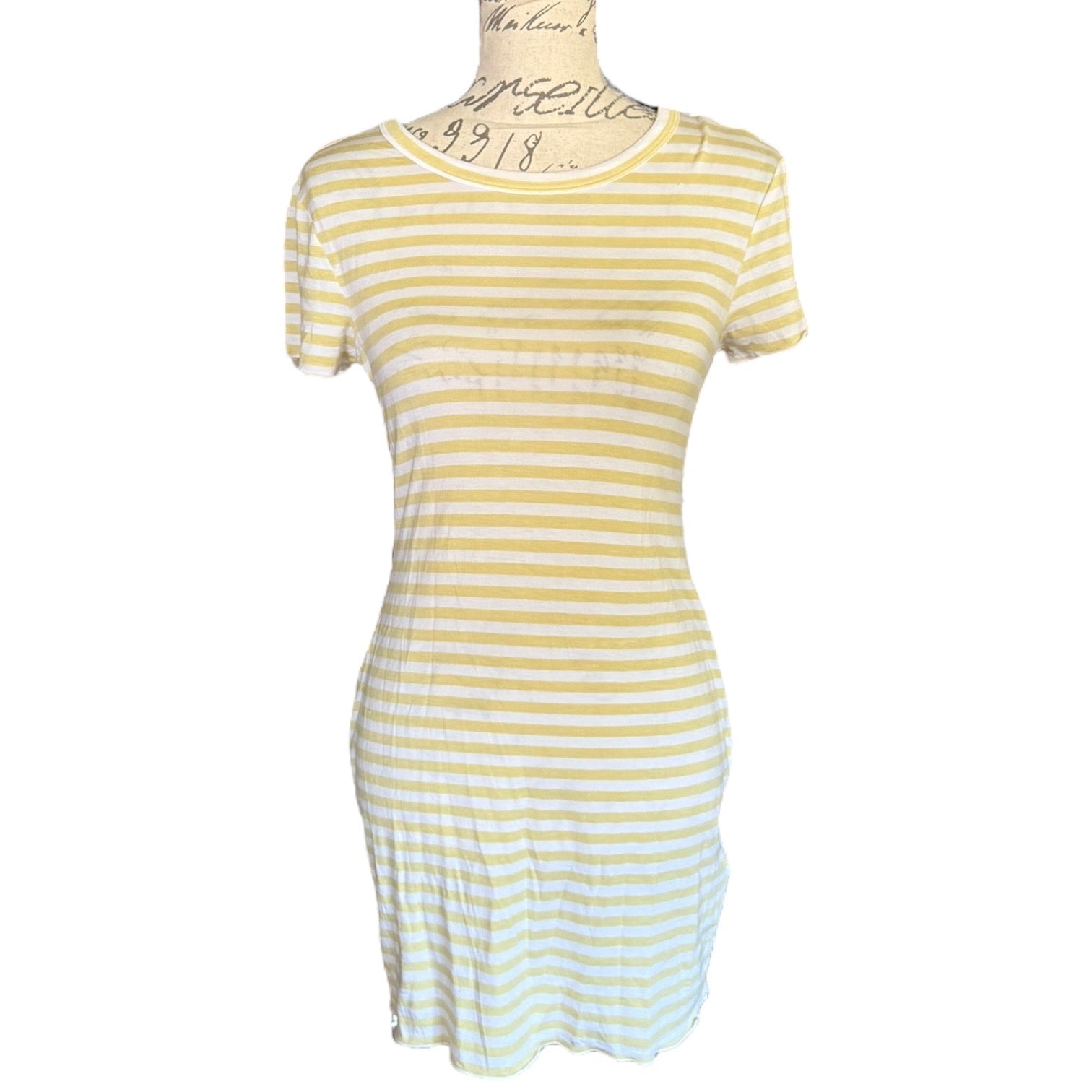 Green and white striped dress on a mannequin against a white background