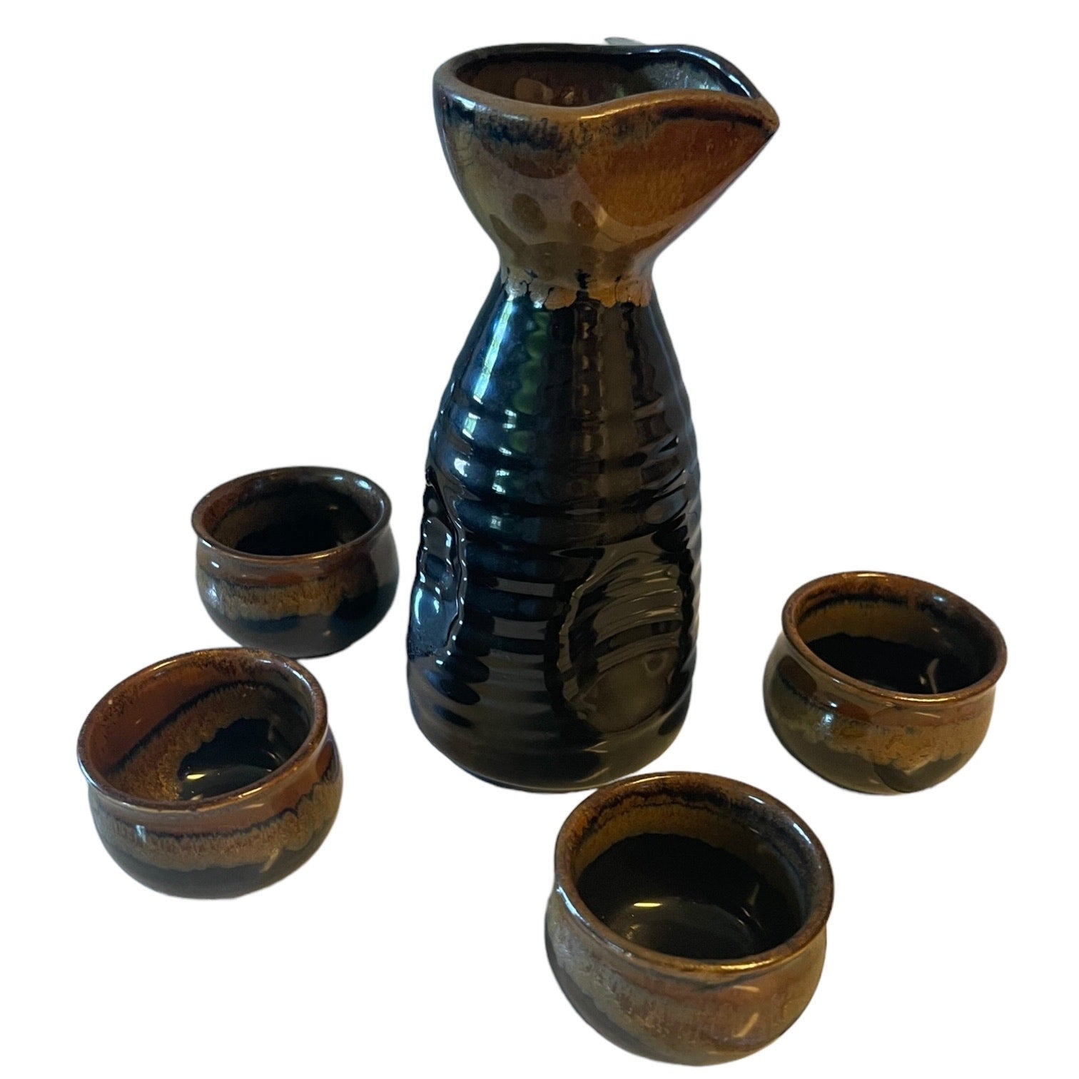 A ceramic sake set featuring a tall carafe and four small matching cups with a glossy dark brown and black glaze, set against a plain white background.
