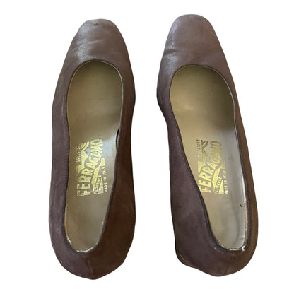 A pair of Ferragamo pointed-toe heels in dark brown suede, shown from a top-down view on a white background.