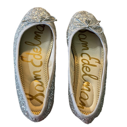 A pair of silver glitter ballet flats with small bow details on the toes, shown from a top-down view on a white background. The insoles feature the brand name 'Sam Edelman' in gold script.