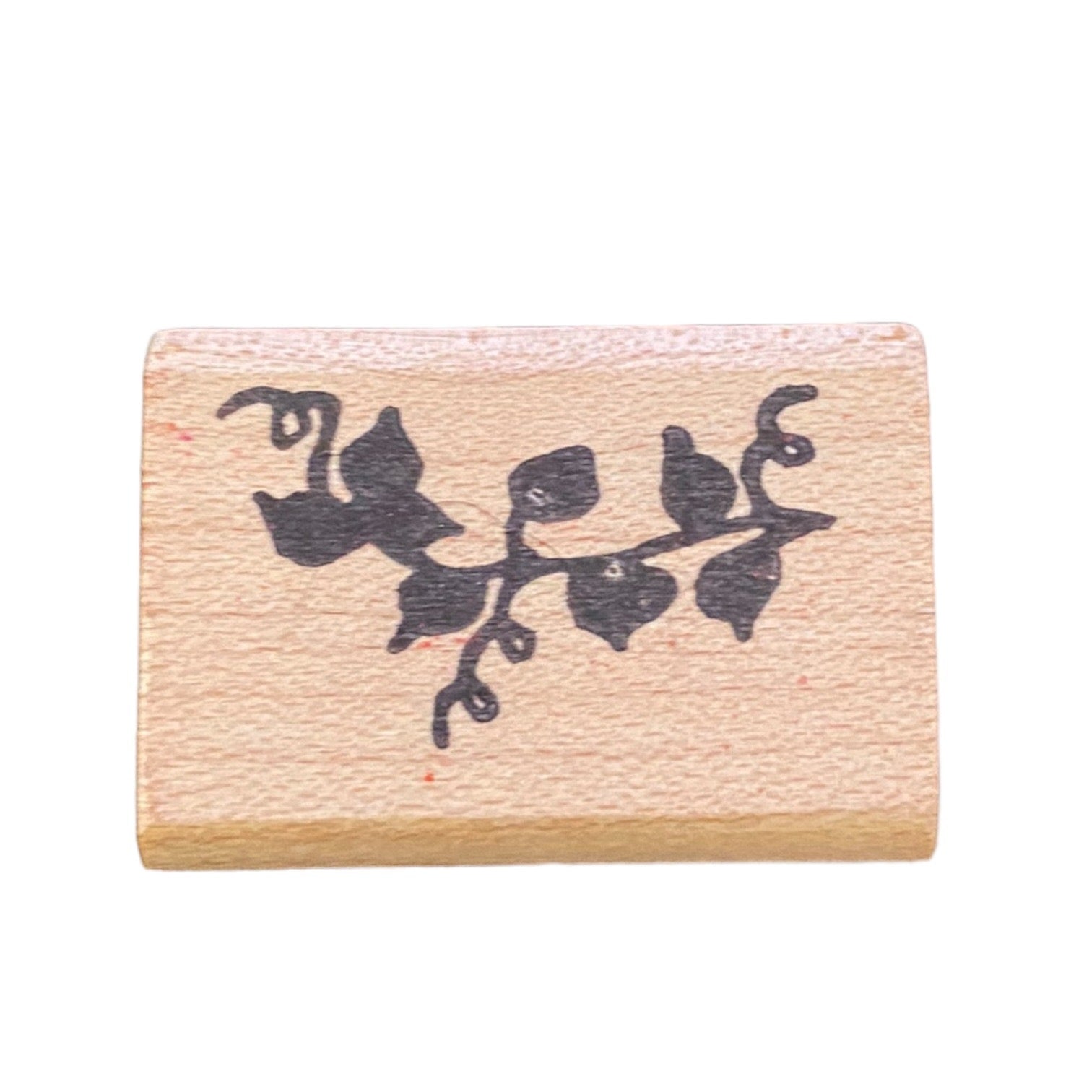 Wooden stamp with black ivy leaf design on a white background