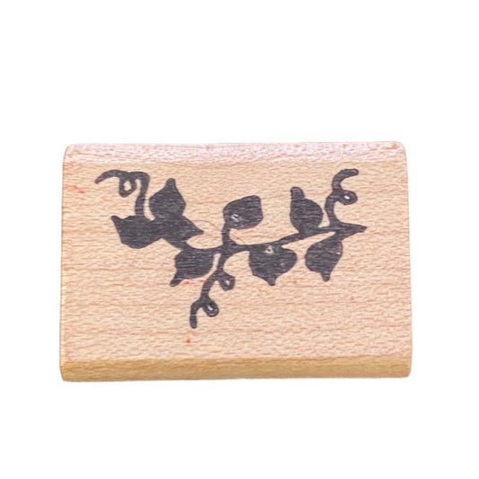 Wooden stamp with black ivy leaf design on a white background