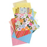 Collection of colorful card stock and paper with floral designs on a white background