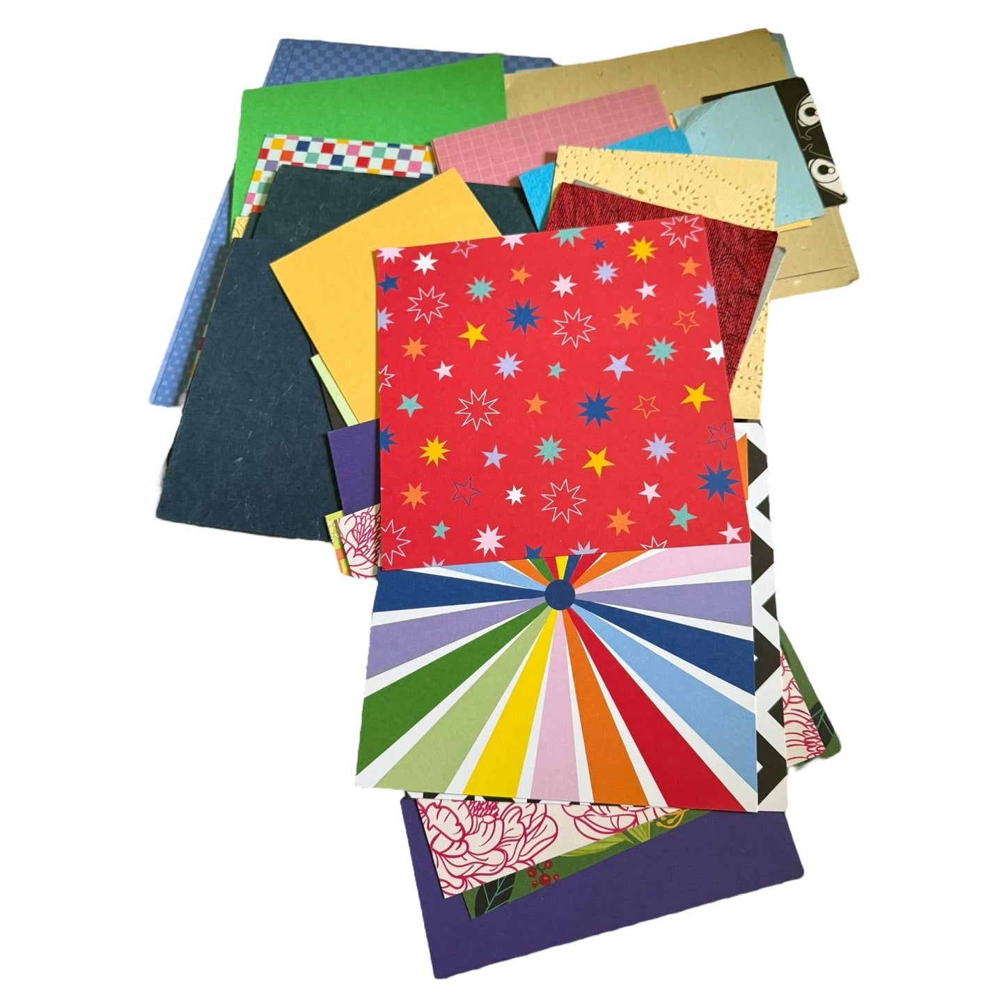 Stack of colorful greeting card stock and paper with various patterns on a white background