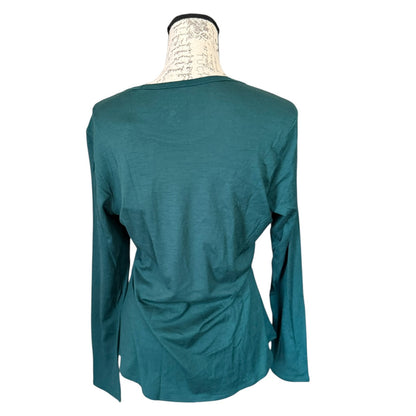 A green long-sleeve top displayed on a cream-colored dress form mannequin against a plain white background.