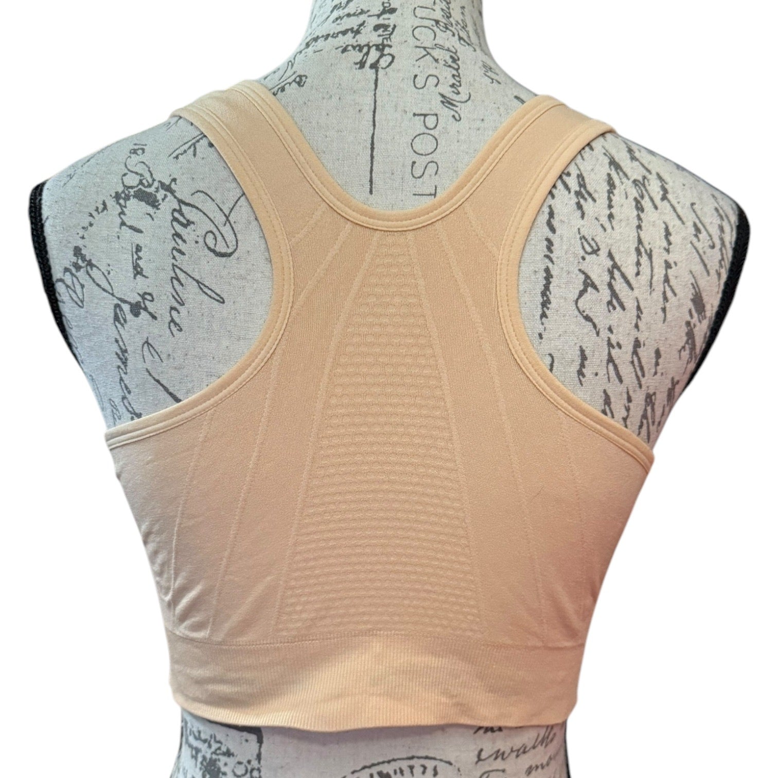 Beige sports bra back on a mannequin with a white background