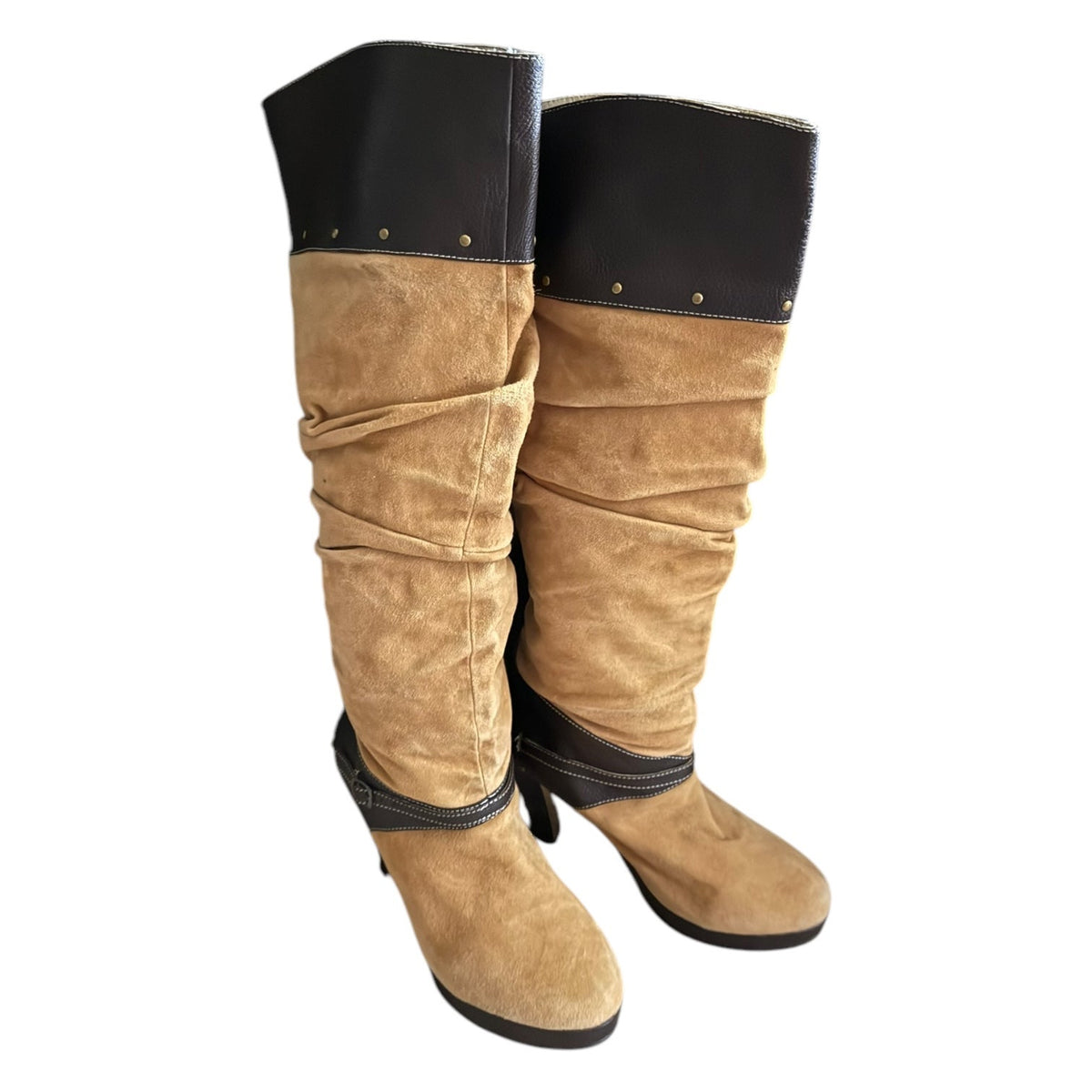 A pair of slouchy knee-high boots in tan suede with brown faux-leather trim at the top and ankle, shown against a plain white background.