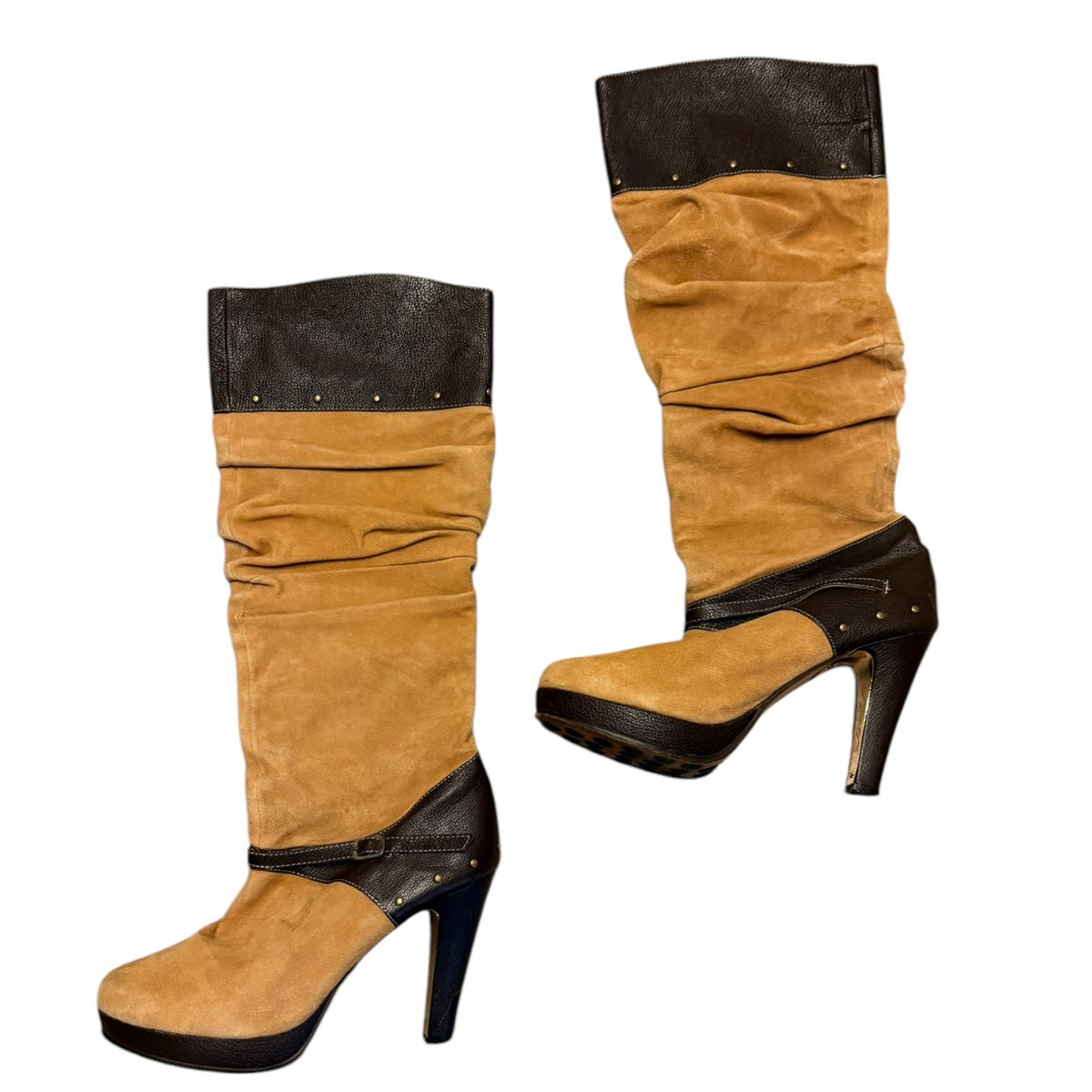 A pair of mid-calf heeled boots in tan suede with brown faux leather trim, studded details, and a ruched slouchy upper, shown on a plain white background.