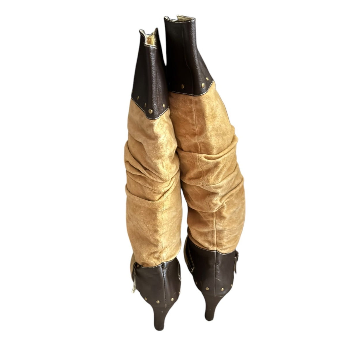 A pair of tall pointed-toe boots with ruched tan suede-like uppers and dark brown faux leather sections at the collar and toe, shown on a plain white background.