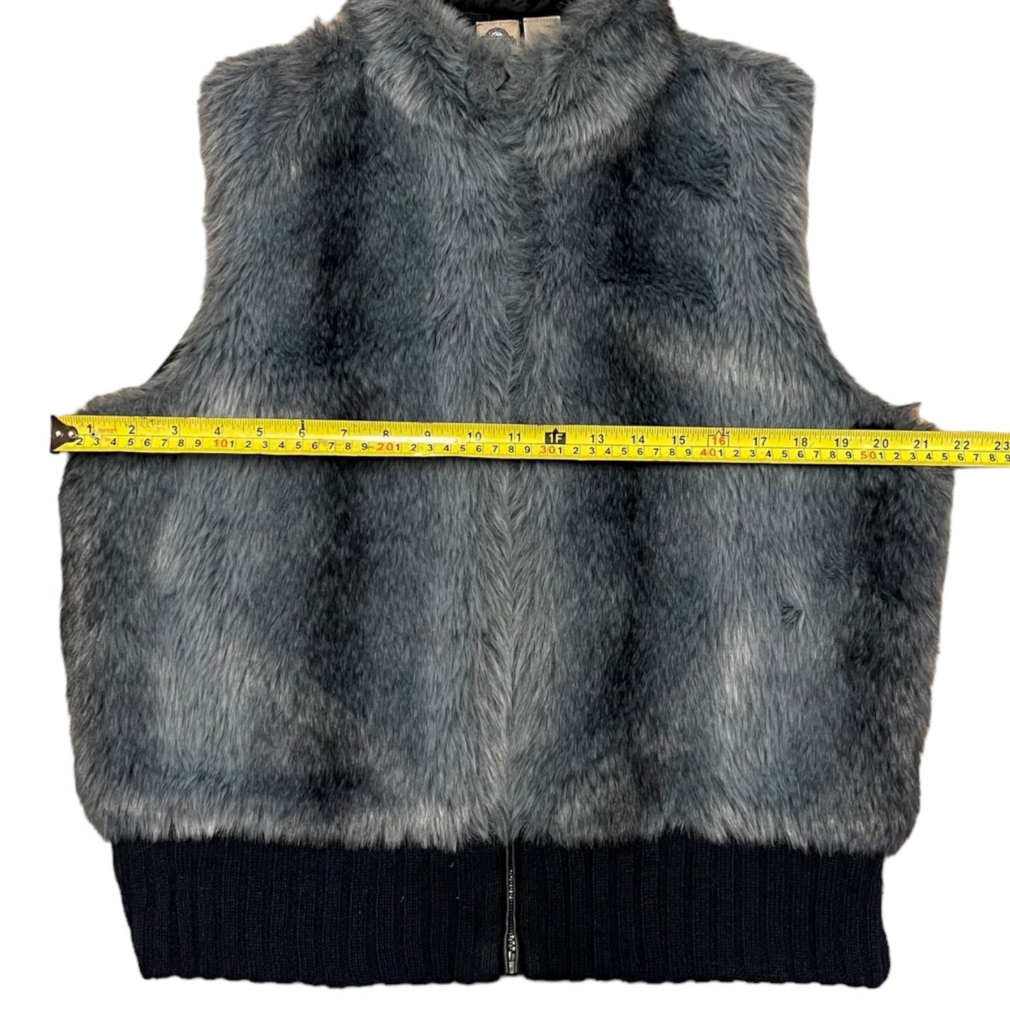 Blue-Gray fur vest with a measuring tape on a white background