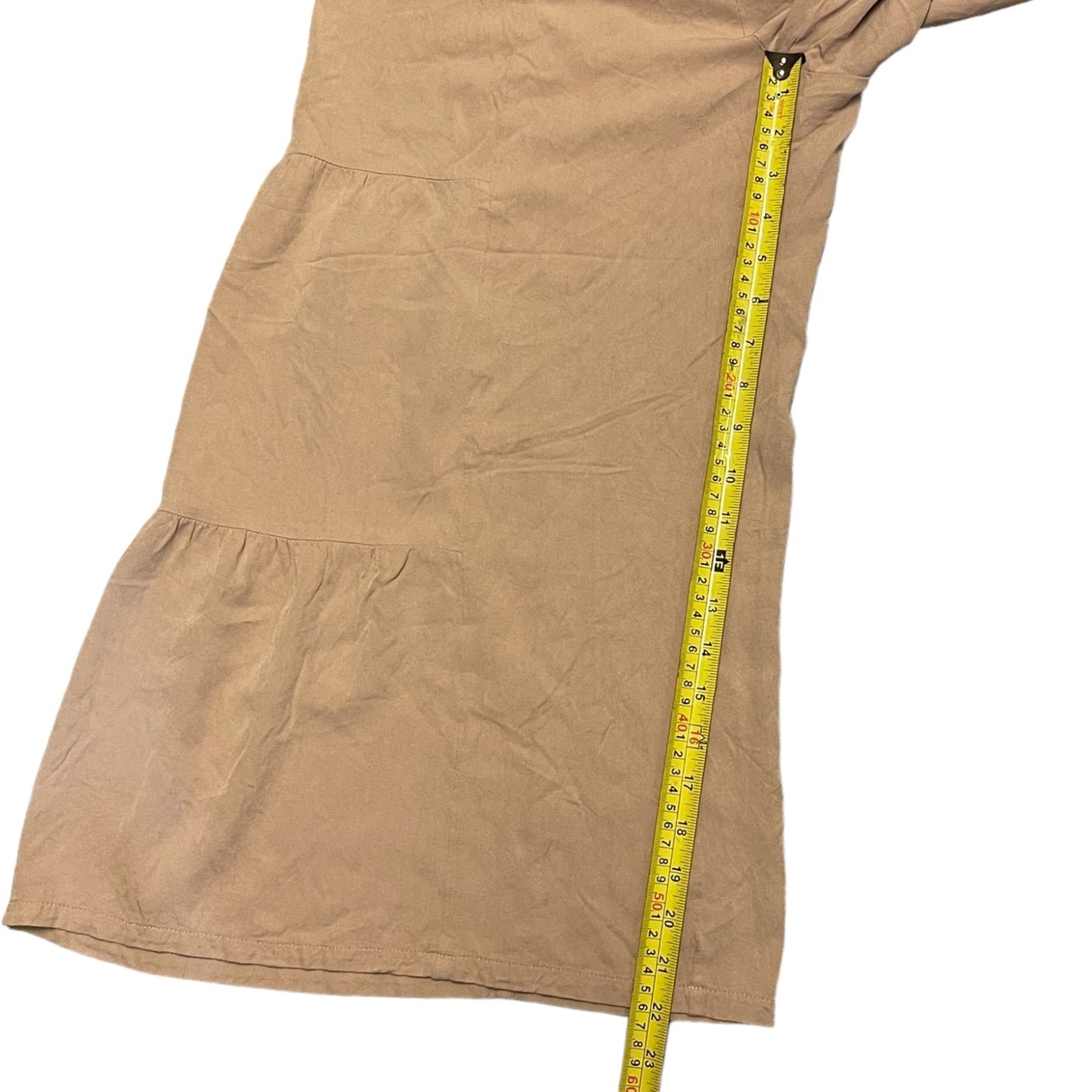 Pants laying laid flat on a white background, shown with a yellow tape measure running vertically along one side to indicate inseam.