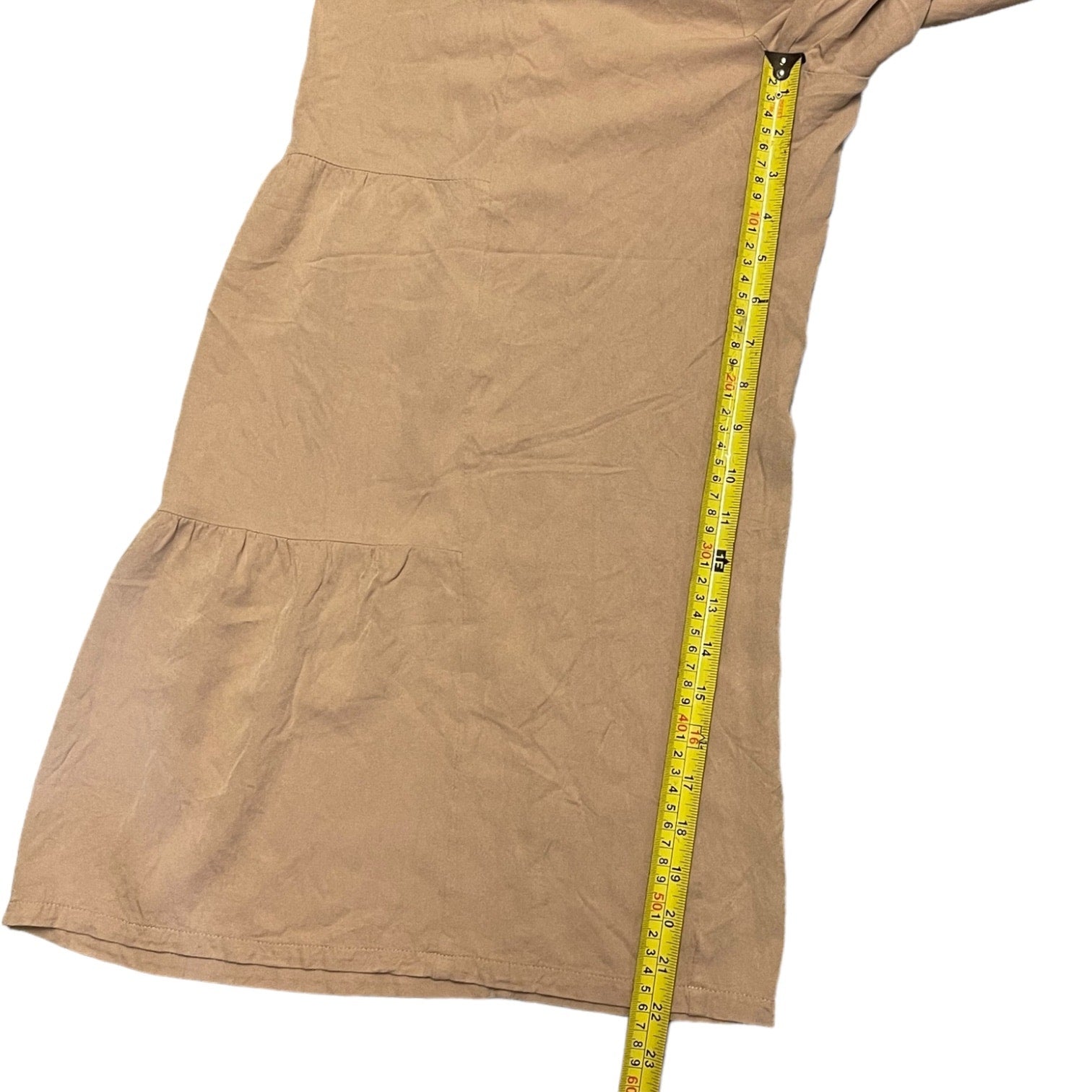Pants laying laid flat on a white background, shown with a yellow tape measure running vertically along one side to indicate inseam.