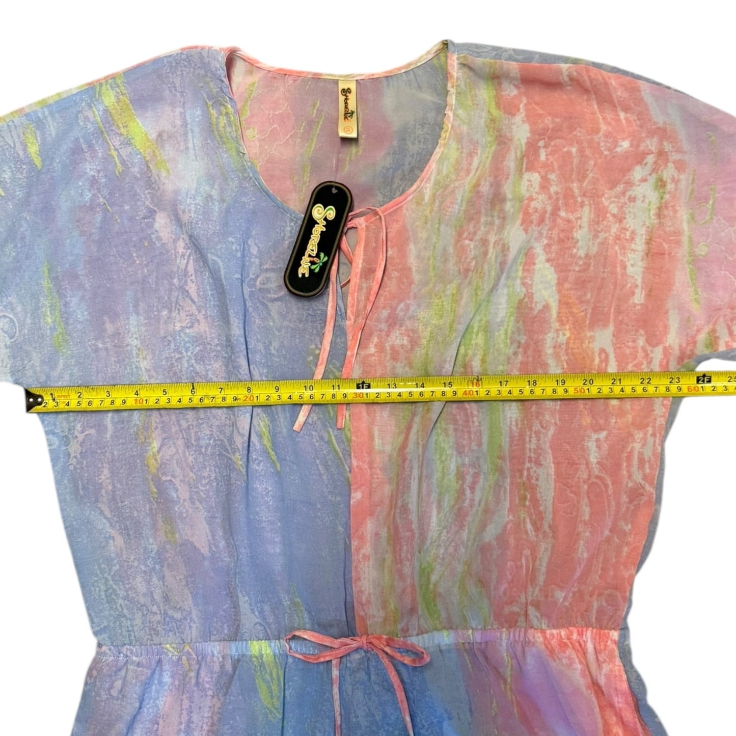 Colorful dress with a measuring tape for size reference on a white background