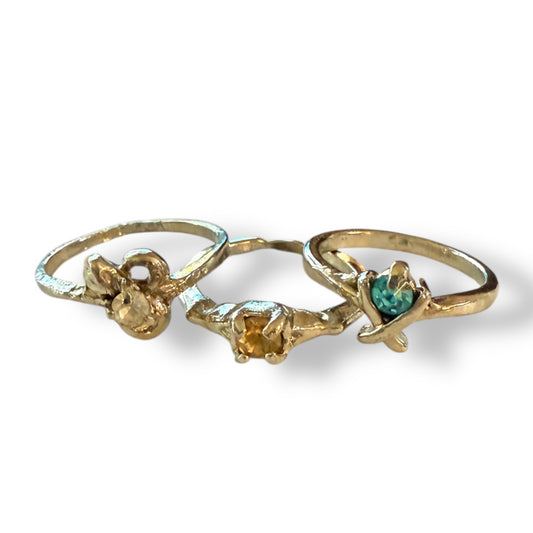Three silver rings with assorted colored stones , displayed on a white background.