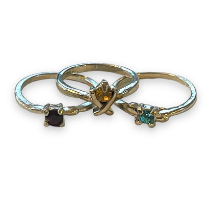 Three silver rings with small gemstones, displayed on a white background.