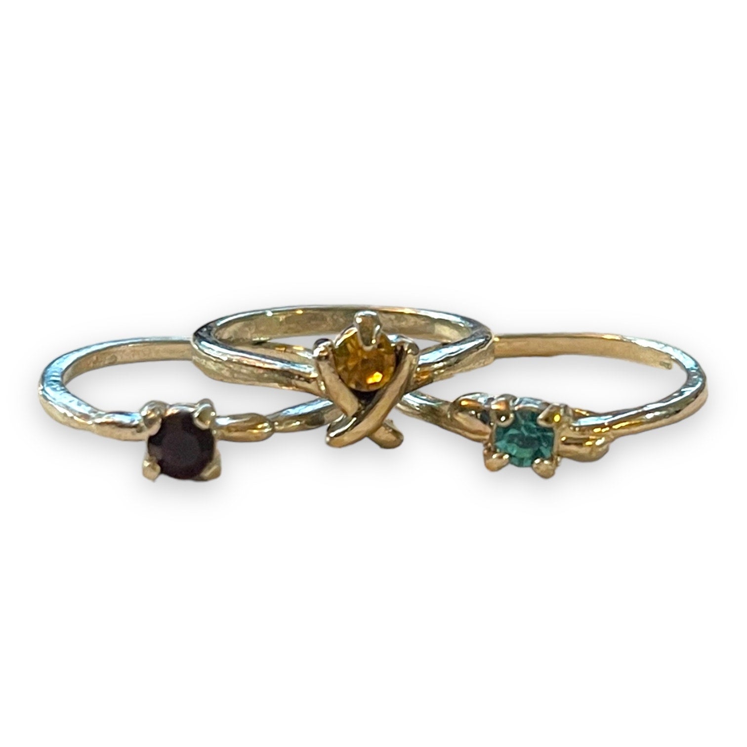 Three silver rings with small gemstone accents on a white background. 
