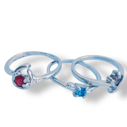 Set of 3 rings with purple, red and blue gemstones on a white background