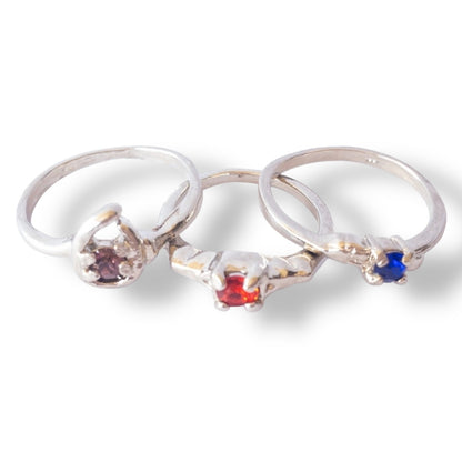 Three silver rings with colored gemstones on a white background