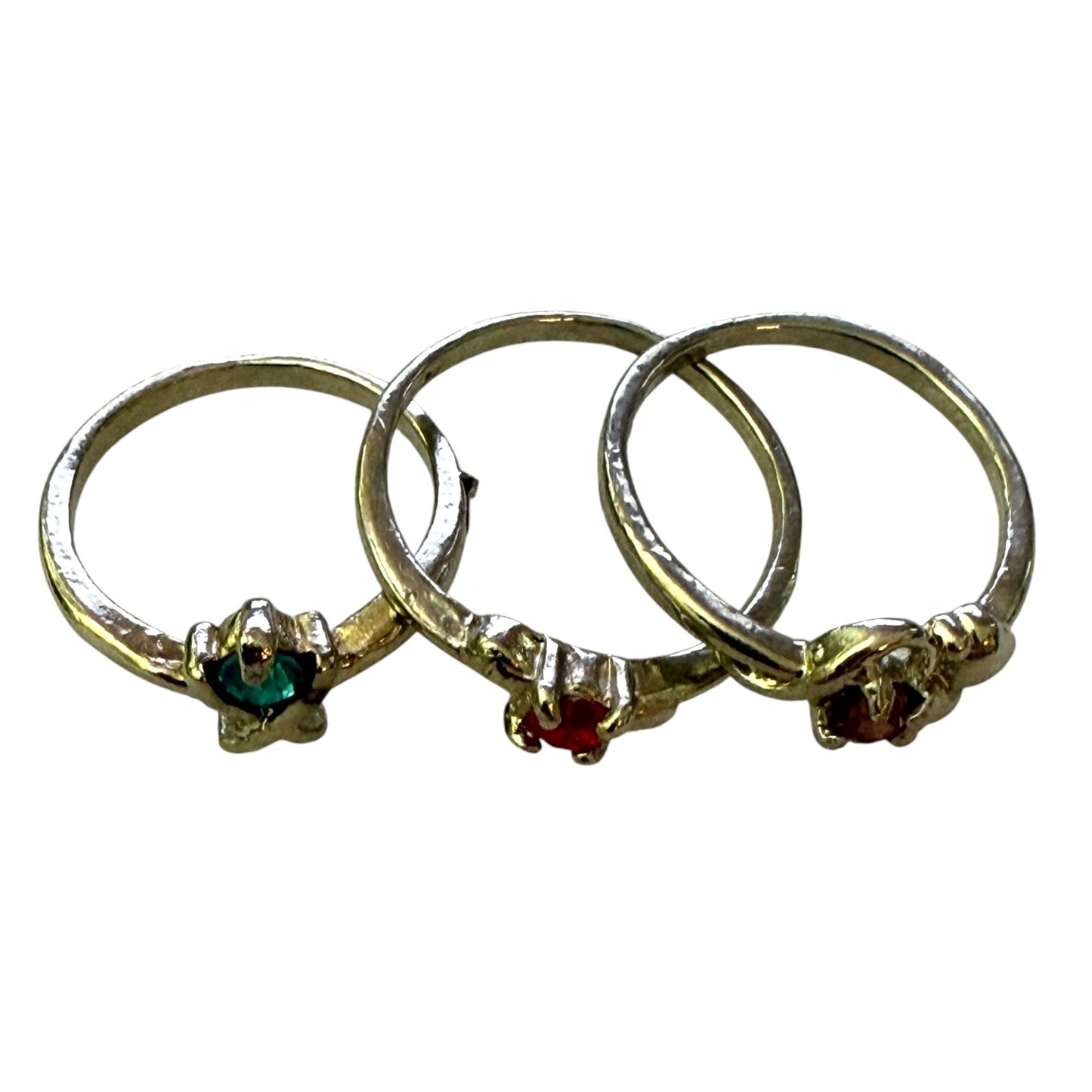 Top view of 3 stackable silver rings with gemstones on a white background