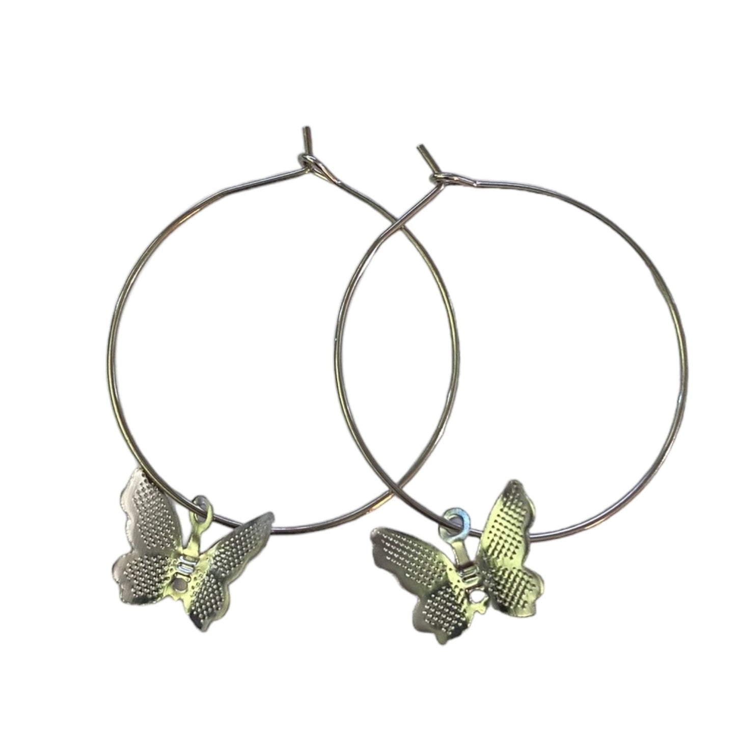 A pair of silver-tone hoop earrings with textured butterfly charms, displayed against a solid white background.