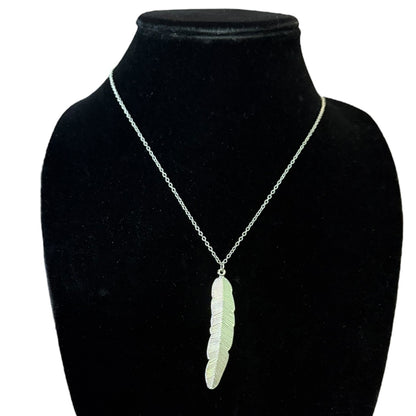 A silver chain necklace with a textured feather pendant, displayed on a black velvet jewelry bust against a white background.