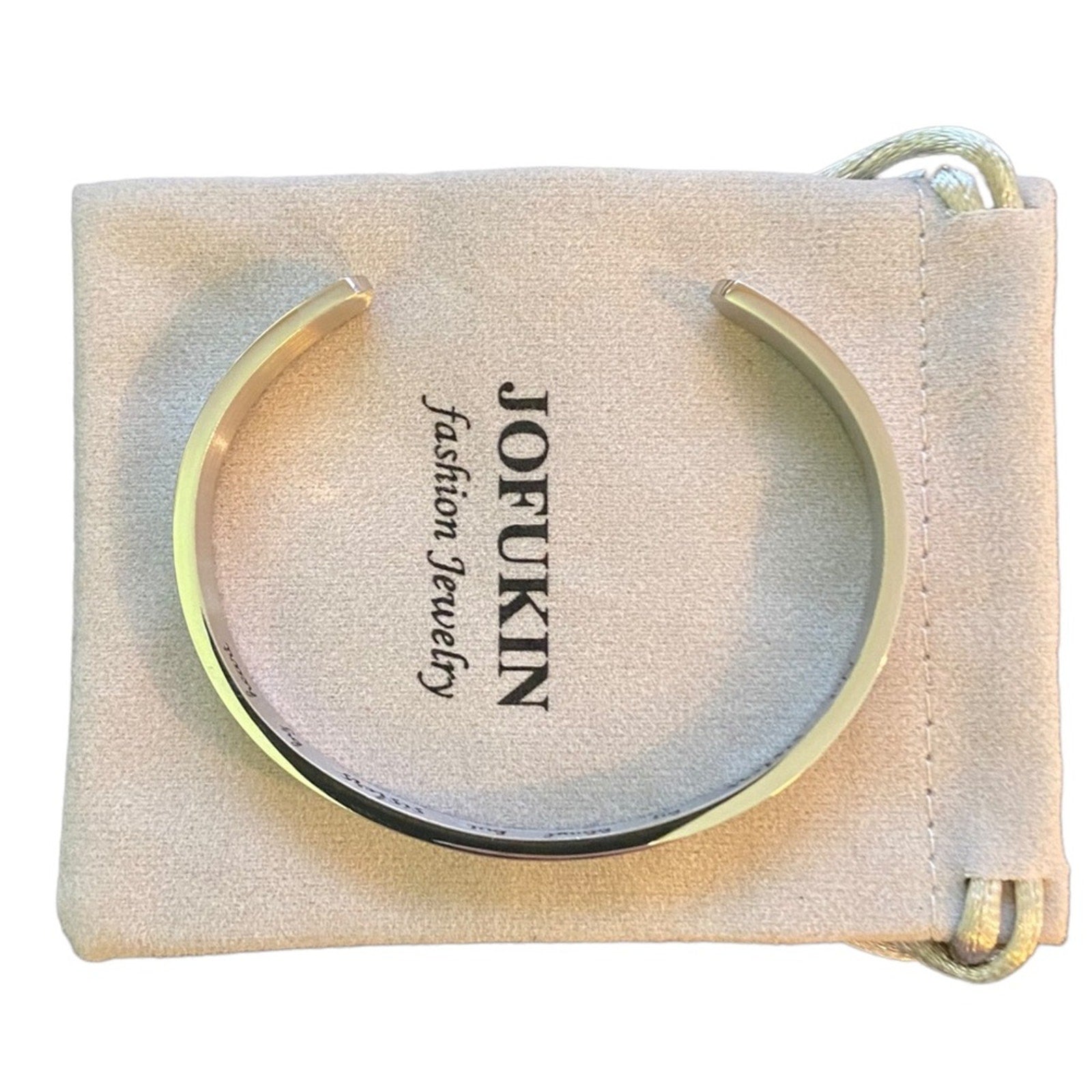 Top of silver cuff bracelet on a beige dust cover