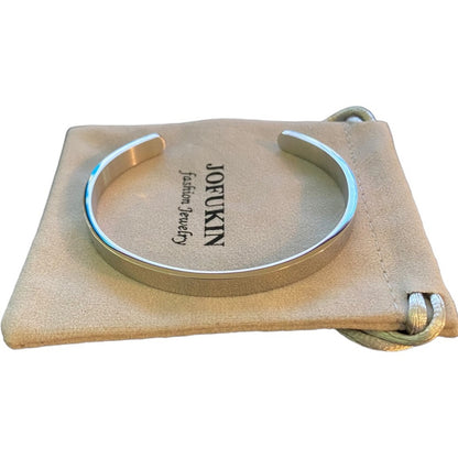 Silver cuff bracelet on a beige jewelry pouch with 'JOFUKIN' branding.
