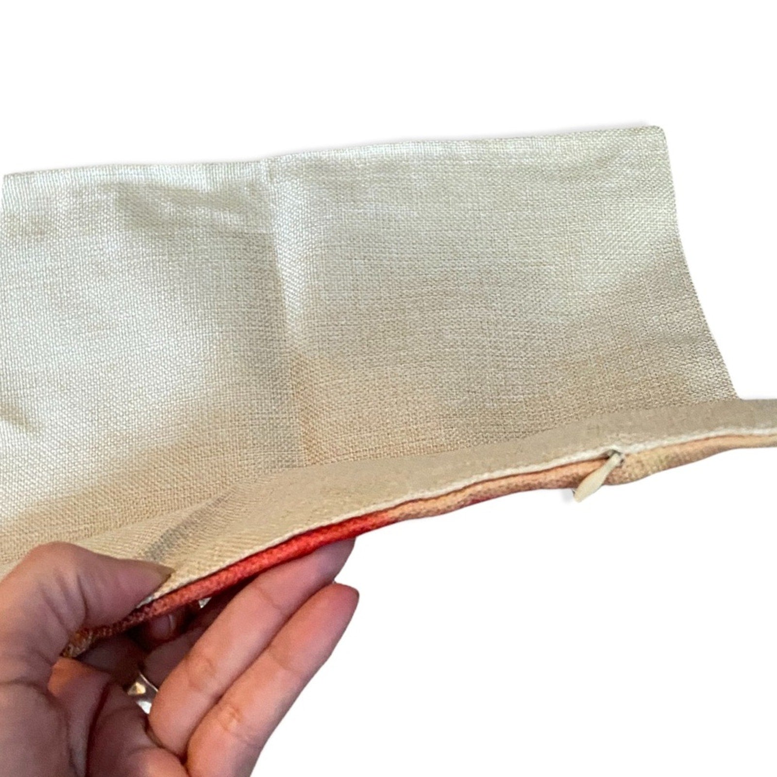 Hand holding a pillowcase with a zipper on a white background