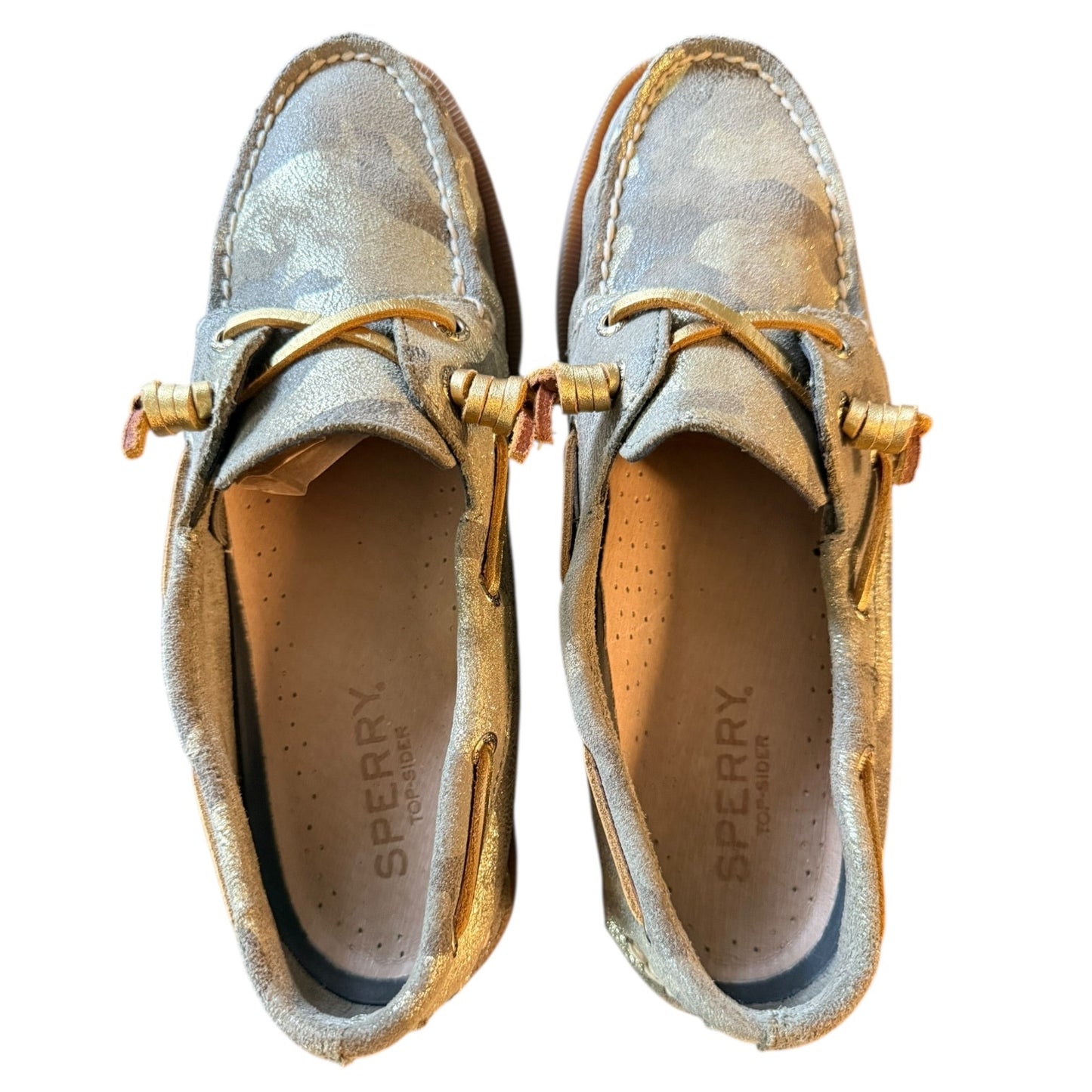 Top of a Pair of Sperry shoes with gold accents on a white background