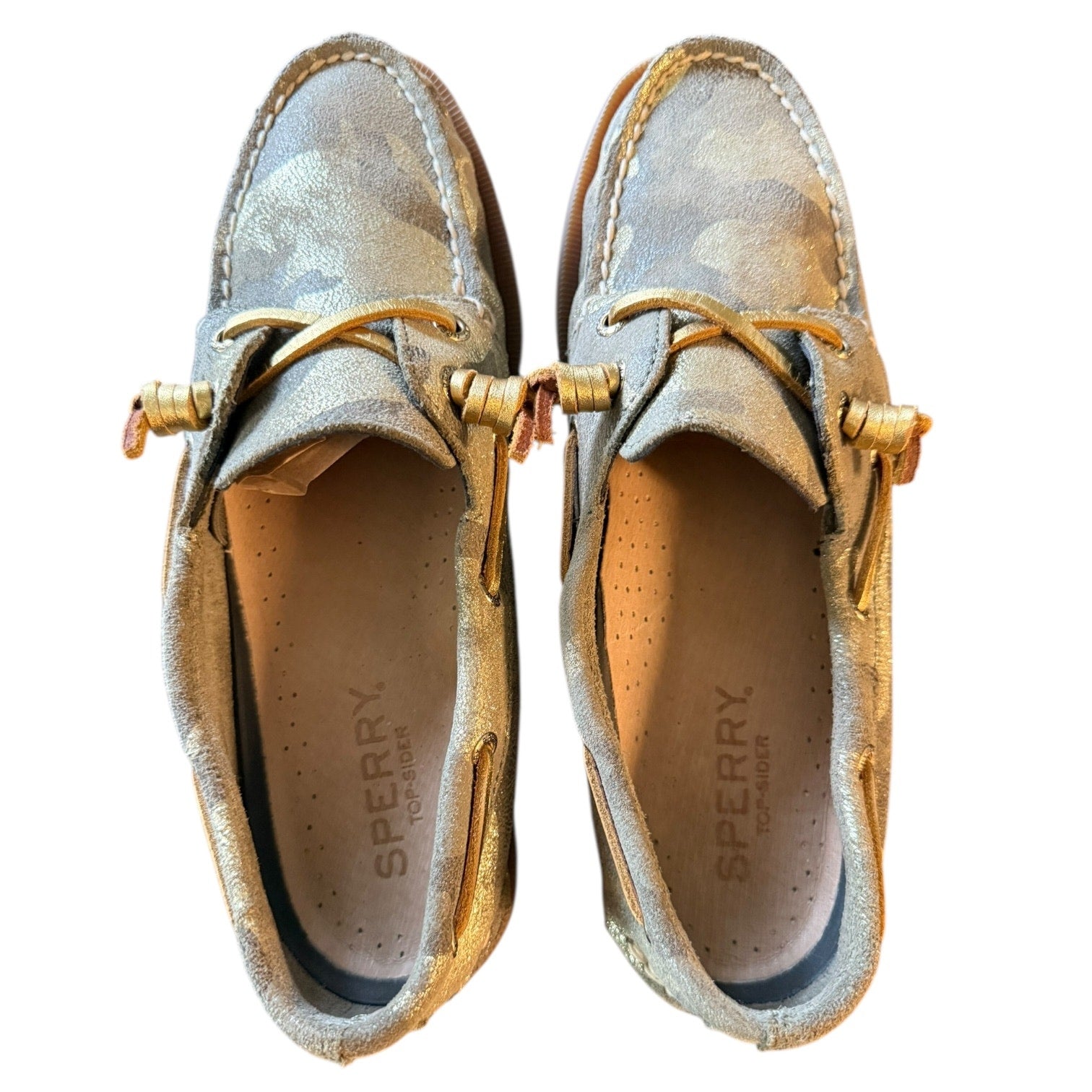 Top of a Pair of Sperry shoes with gold accents on a white background
