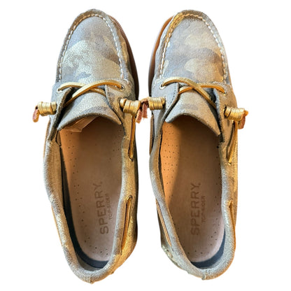Top of a Pair of Sperry shoes with gold accents on a white background