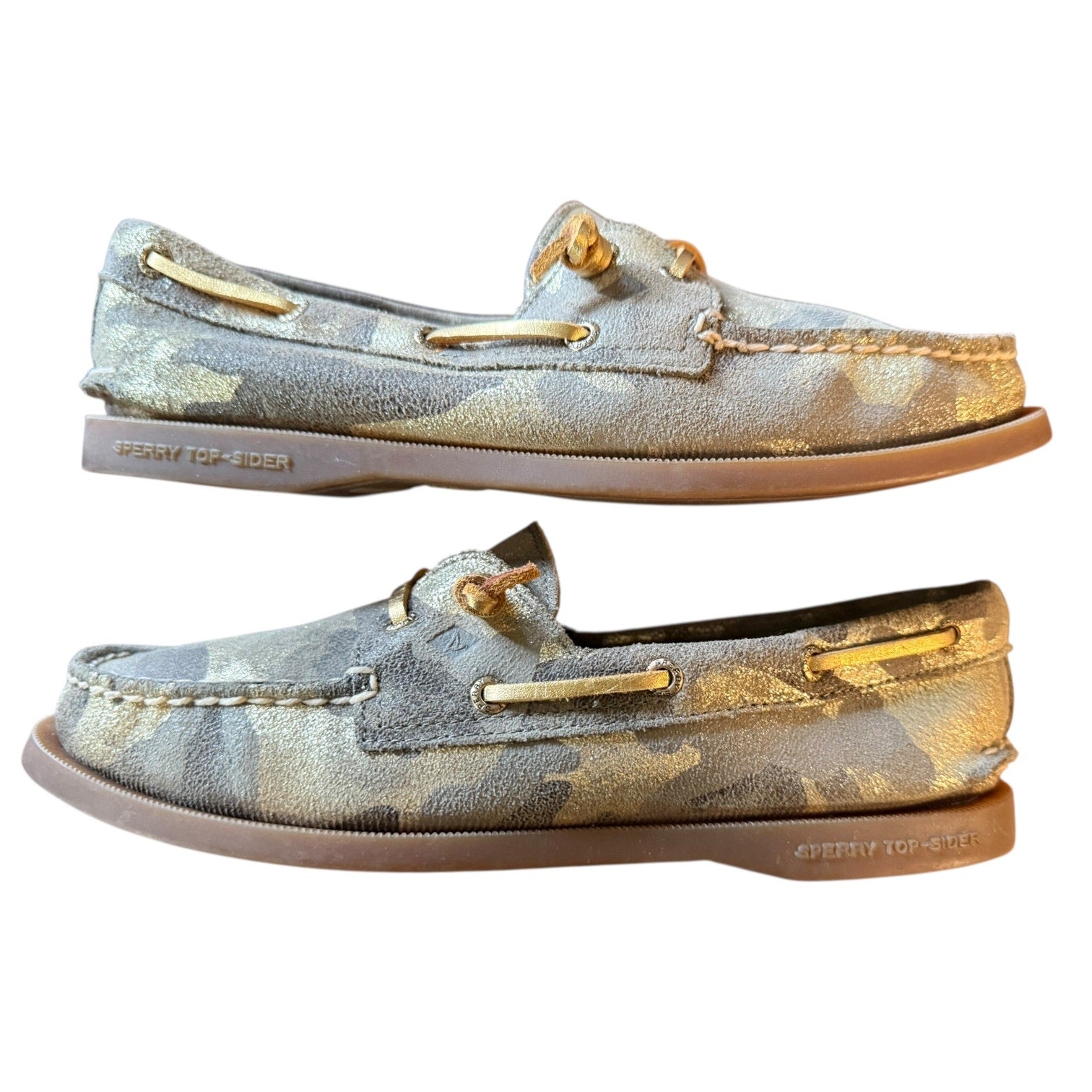 Side view of a Pair of camouflage-patterned boat shoes with gold accents on a white background