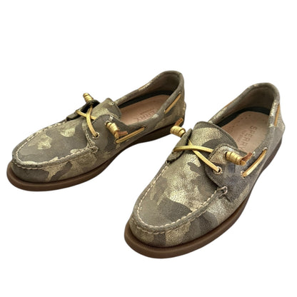 Front side Pair of camouflage-patterned boat shoes with gold laces on a white background