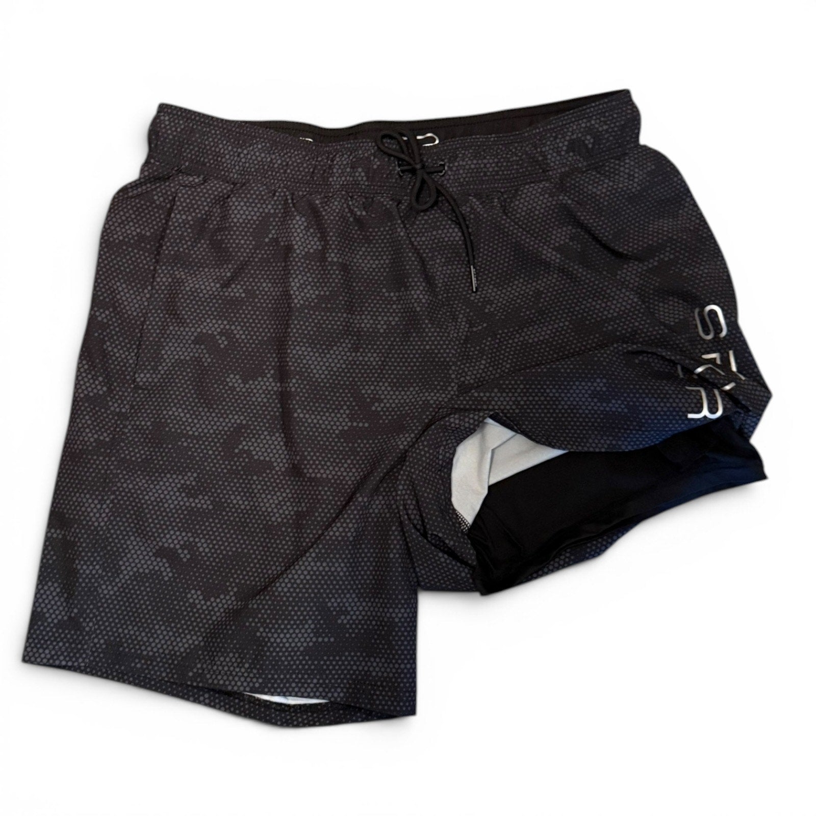 Black patterned shorts with built in boxer briefs and brand logo on a white background