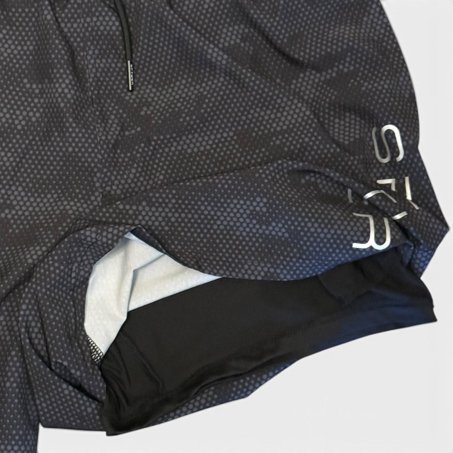 Close-up of a black and gray textured shorts with a brand logo on a white background