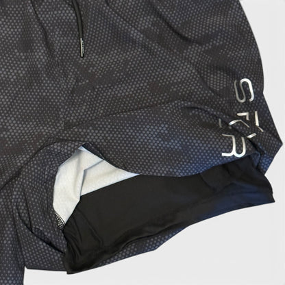 Close-up of a black and gray textured shorts with a brand logo on a white background