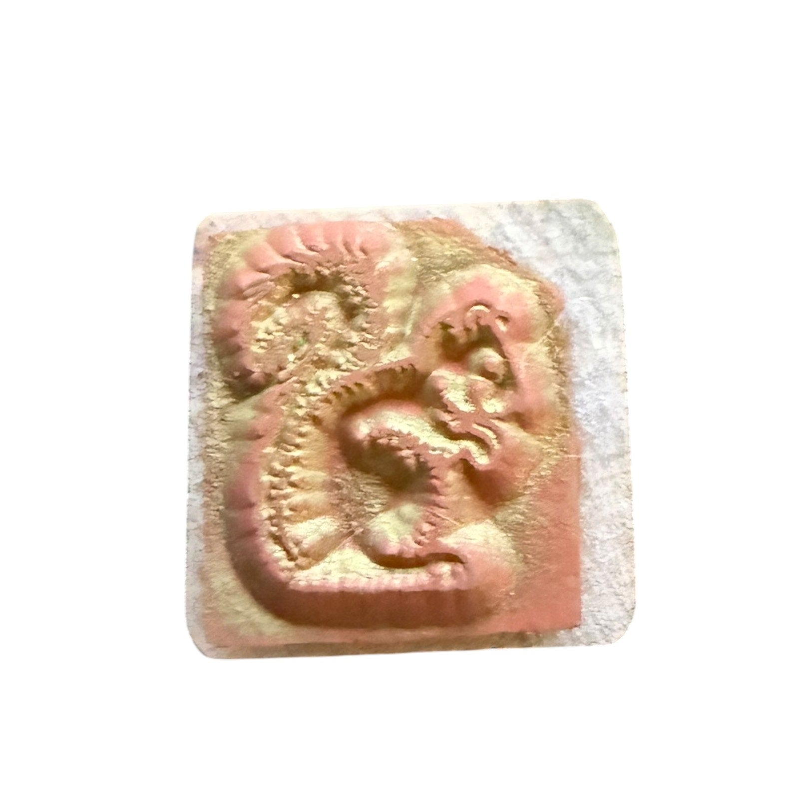 Rubber stamp with ink marks on a white background