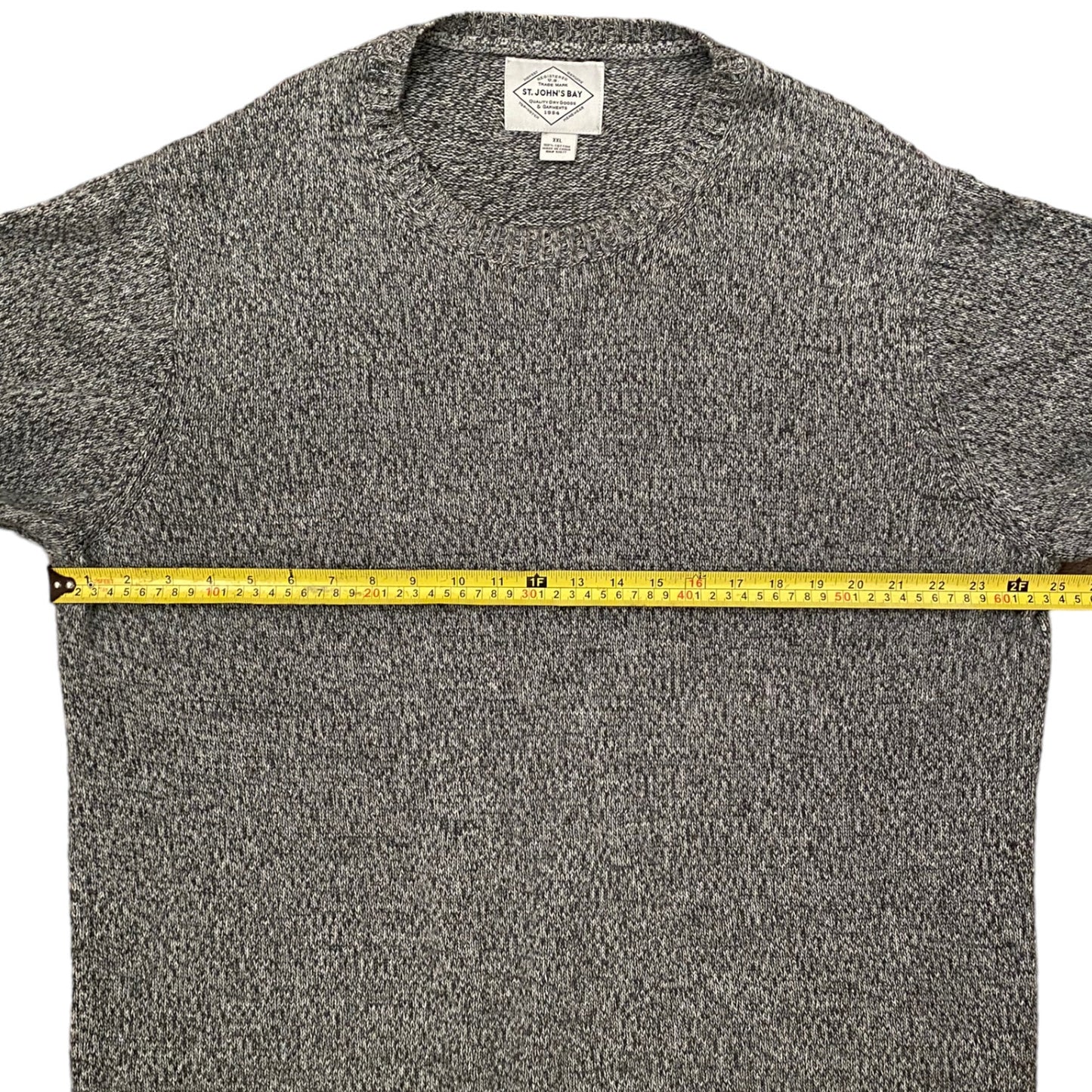 Gray sweater with a measuring tape across it on a white background