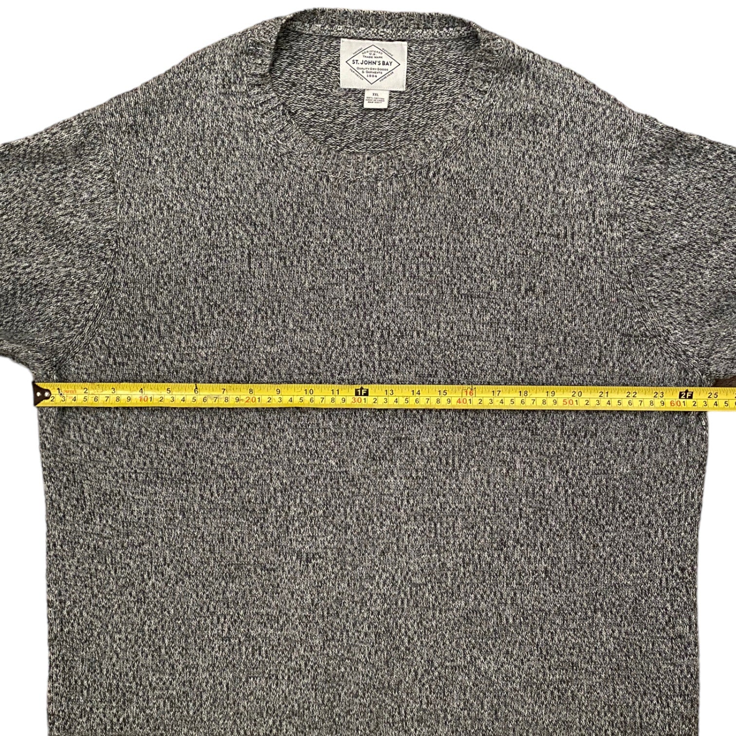 Gray sweater with a measuring tape across it on a white background