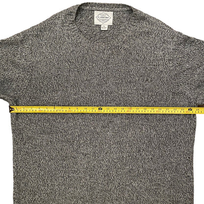 Gray sweater with a measuring tape across it on a white background
