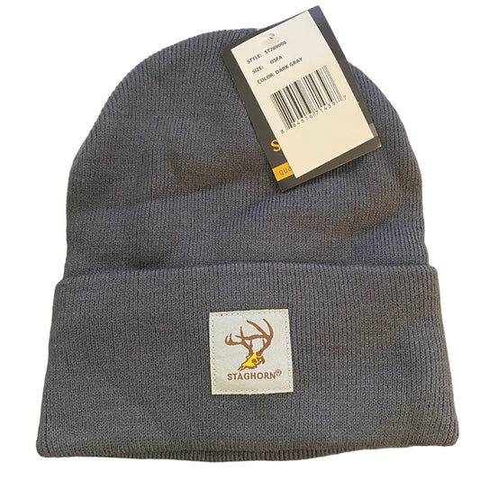 A dark gray knit beanie hat with a folded cuff, featuring a Staghorn brand patch on the front and a product tag attached near the top. 