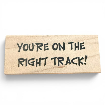 Wooden block with 'You're on the right track!' text on a white background