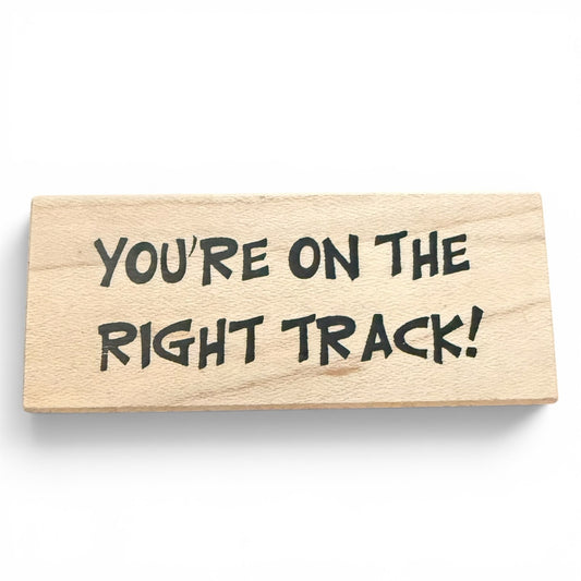 Wooden block with 'You're on the right track!' text on a white background