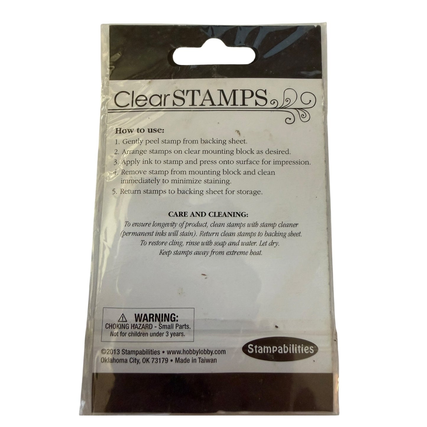 Clear STAMPS stamping block packaging by Stampabilities, showing the back of the clear plastic bag with printed instructions, a warning label, and the Stampabilities logo.